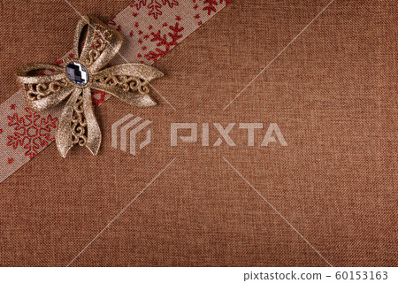 Gold glitter bow and festive ribbon on brown 60153163