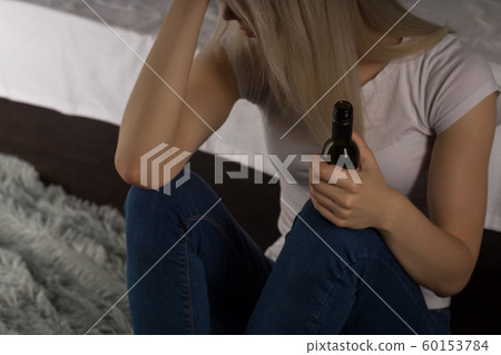 Teen girl suffering from a hangover while sitting Teen girl suffering from a hangover while sitting 60153784