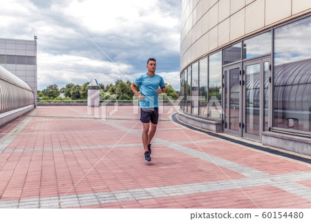male athlete runs in morning on run, in motion, workout training, in summer in the city. Fitness motivation youth lifestyle. Free space for copy text. 60154480