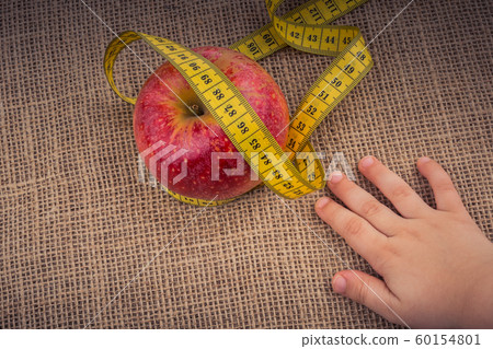 Red apple with a measurement tape on it Red apple with a measurement tape on it 60154801