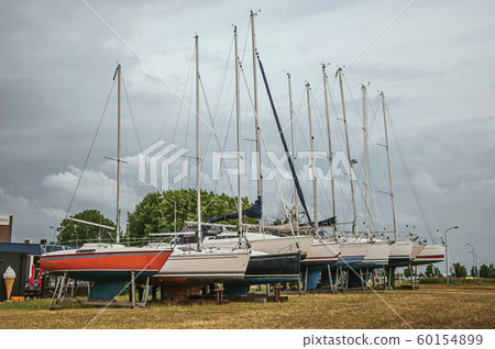 Several sailboats collected in brackets for repair Several sailboats collected in brackets for repair 60154899