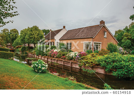 Canal next to rustic houses with flowery garden at Drimmelen 60154918