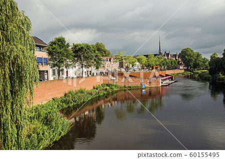Trees with vegetation and houses next to the Dommel River Trees with vegetation and houses next to the Dommel River 60155495
