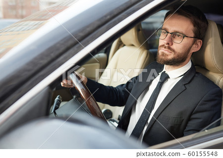 Serious businessman sitting in the car 60155548