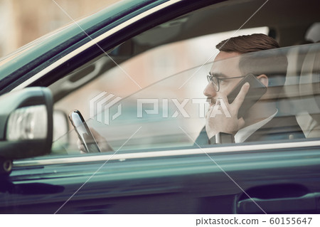 Man using mobile phone in the car Man using mobile phone in the car 60155647