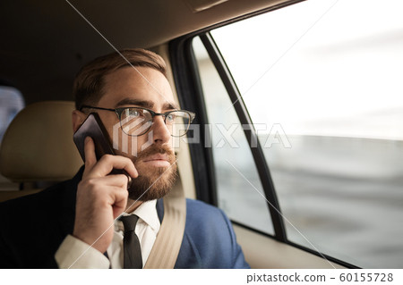 Businessman talking on the phone in taxi 60155728