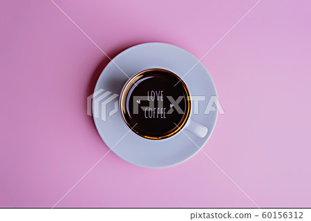 Cup of coffee on a saucer on a pale pink background. Cup of coffee on a saucer on a pale pink background. 60156312