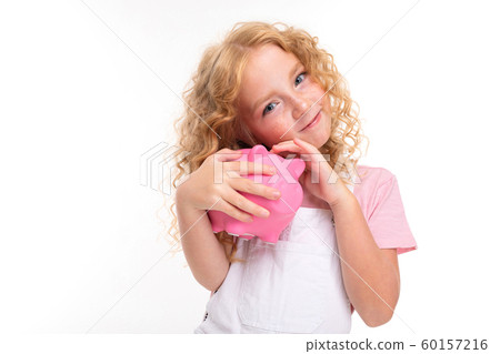 attractive blond curly girl holding a piggy bank in her hands on a light blue background attractive blond curly girl holding a piggy bank in her hands on a light blue background 60157216