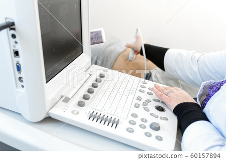 Close-up ultrasound machine doctor performs Close-up ultrasound machine doctor performs 60157894