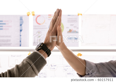 Hands of two successful partners in high-five gesture after making agreement Hands of two successful partners in high-five gesture after making agreement 60157911