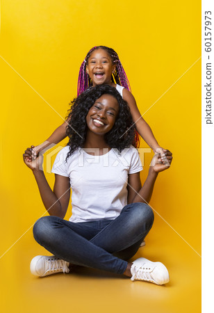 Beautiful mom sitting on floor and holding hands with daughter 60157973