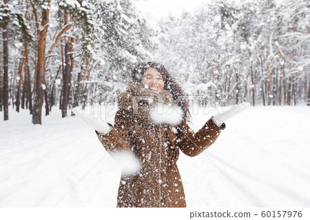 Cheerful Girl Throwing Snow Making Snowfall In Beautiful Forest Cheerful Girl Throwing Snow Making Snowfall In Beautiful Forest 60157976