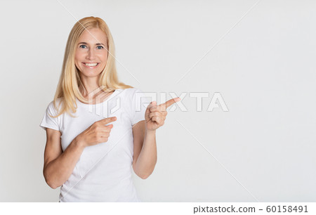Look here! Happy woman pointing aside on copy space Look here! Happy woman pointing aside on copy space 60158491