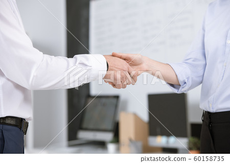 Two successful business partners greeting each other by handshake Two successful business partners greeting each other by handshake 60158735