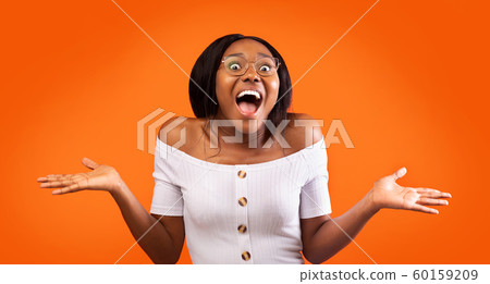 Excited Afro Girl Shouting Gesturing With Hands Standing, Orange Background Excited Afro Girl Shouting Gesturing With Hands Standing, Orange Background 60159209