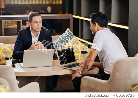 Coworkers discussing investment strategy Coworkers discussing investment strategy 60169726