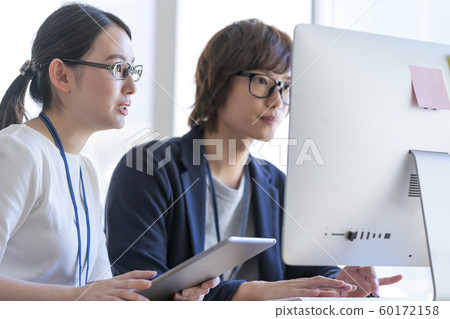 Office work image Young man and woman looking at computer screen Office work image Young man and woman looking at computer screen 60172158