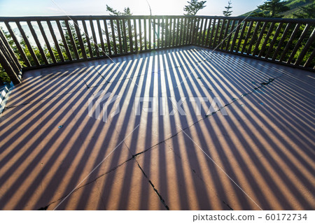 The fence becomes a silhouette in the morning glow and casts a shadow on the floor like a perspective The fence becomes a silhouette in the morning glow and casts a shadow on the floor like a perspective 60172734