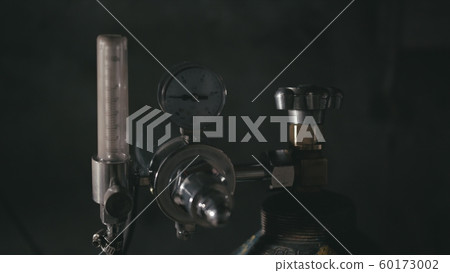 Forge workshop. Smithy manual production. A worker open gas cylinder vessel with oxygen for welding. Cinematic black look. Forge workshop. Smithy manual production. A worker open gas cylinder vessel with oxygen for welding. Cinematic black look. 60173002