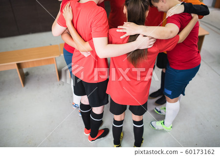 Group of young sporty women in sportswear standing in circle and embracing Group of young sporty women in sportswear standing in circle and embracing 60173162