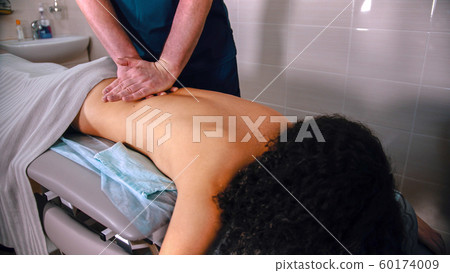 Chiropractic treatment - the doctor giving the patient a massage - softly pushing down on the back with hands Chiropractic treatment - the doctor giving the patient a massage - softly pushing down on the back with hands 60174009
