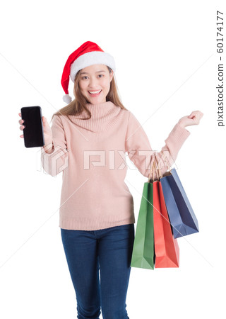 Beautiful asian girl wearing santa claus hat ,carrying many paper shopping bags Beautiful asian girl wearing santa claus hat ,carrying many paper shopping bags 60174177
