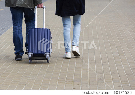 a man and a woman with a suitcase are on the a man and a woman with a suitcase are on the 60175526