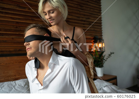 Pretty lady is using black tie in bedroom Pretty lady is using black tie in bedroom 60176025