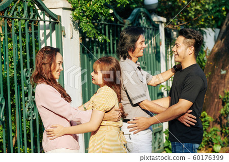 Parents hugging daughter and son 60176399
