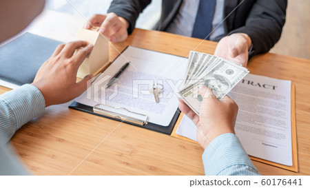 Businessman signs contract behind home 60176441