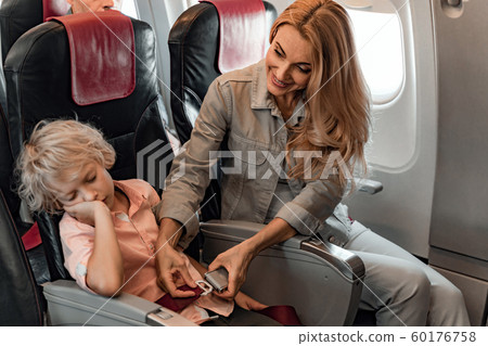 Little boy is sleeping in an airplane chair Little boy is sleeping in an airplane chair 60176758