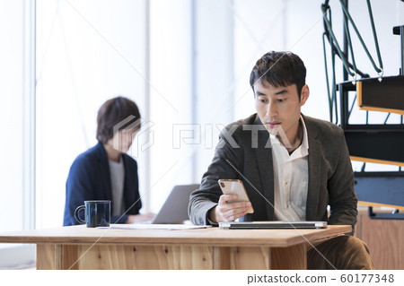 Casual business image A man looking at a smartphone screen 60177348