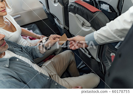 Man giving payment card to the flight attendant 60178755