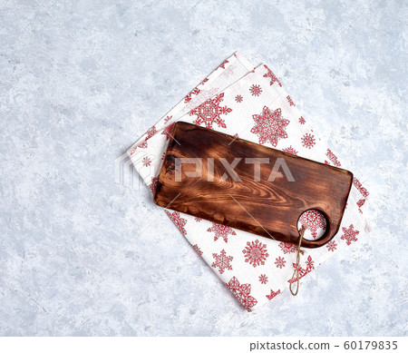 Empty kitchen cutting board with red christmas tablecloth. View from top. 60179835
