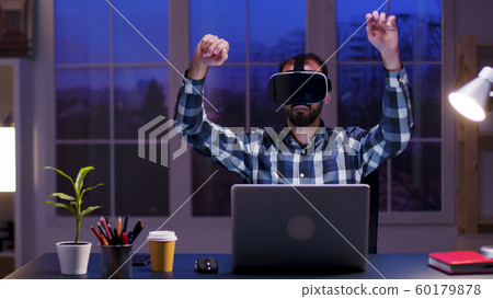 Caucasian businessman in home office wearing virtual reality goggles 60179878