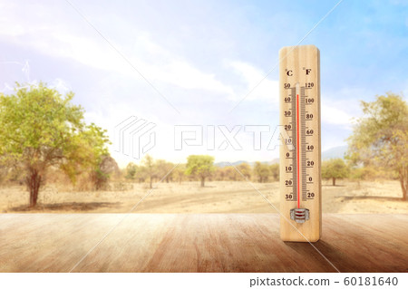 The thermometer on a wooden table measuring the temperature outdoor  60181640