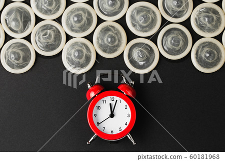 red alarm clock with condoms on black background red alarm clock with condoms on black background 60181968