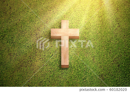 Christian cross on the green grass Christian cross on the green grass 60182020