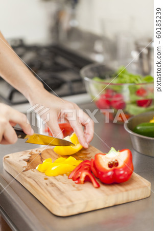 Hand of woman cutting vegetables with kitchen knife Hand of woman cutting vegetables with kitchen knife 60185239
