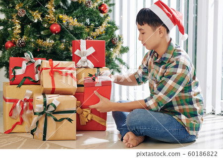 Teenage boy opening presents Teenage boy opening presents 60186822