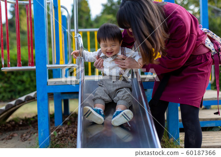 Parent and child playing in the park Parent and child playing in the park 60187366