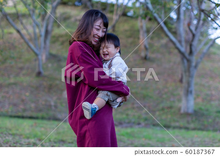 Parent and child playing in the park Parent and child playing in the park 60187367
