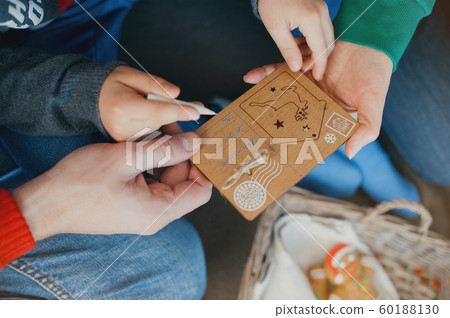 The family writes a letter to Santa Claus. Hands 60188130