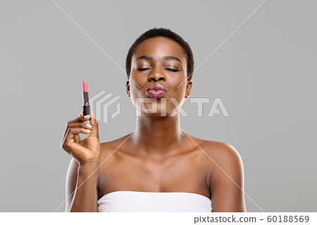Pretty Afro Woman Holding Pink Lipstick and Sending Air Kiss 60188569