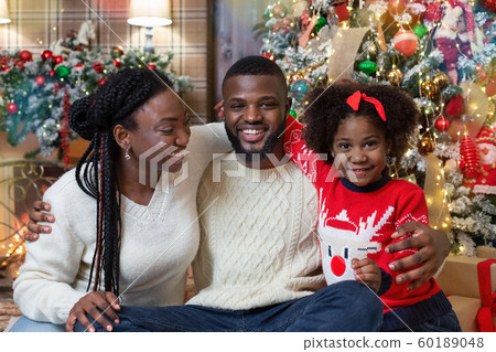Portrait of joyful black family in interior decorated for Christmas 60189048