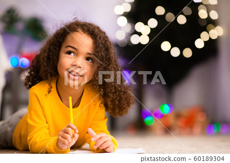 Pensive cute little afro girl thinking about gift ask from Santa Pensive cute little afro girl thinking about gift ask from Santa 60189304