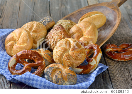 Fresh Bavarian rolls and pretzels on a vintage baking board 60189343