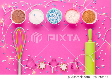 ingredients for baking and kitchen tools with cookie cutter on pink background 60190554