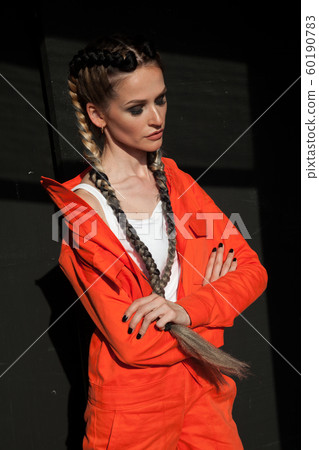 beautiful fashionable woman with braids in orange clothes 60190783