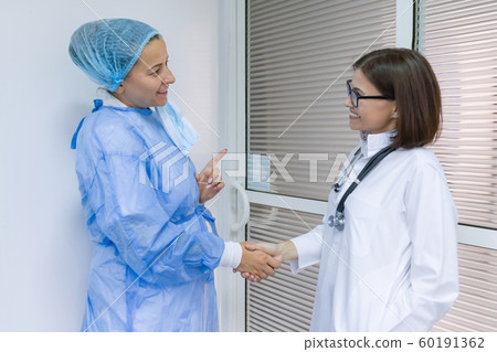 Colleagues doctor surgical doctor and therapist talking in hospital Colleagues doctor surgical doctor and therapist talking in hospital 60191362